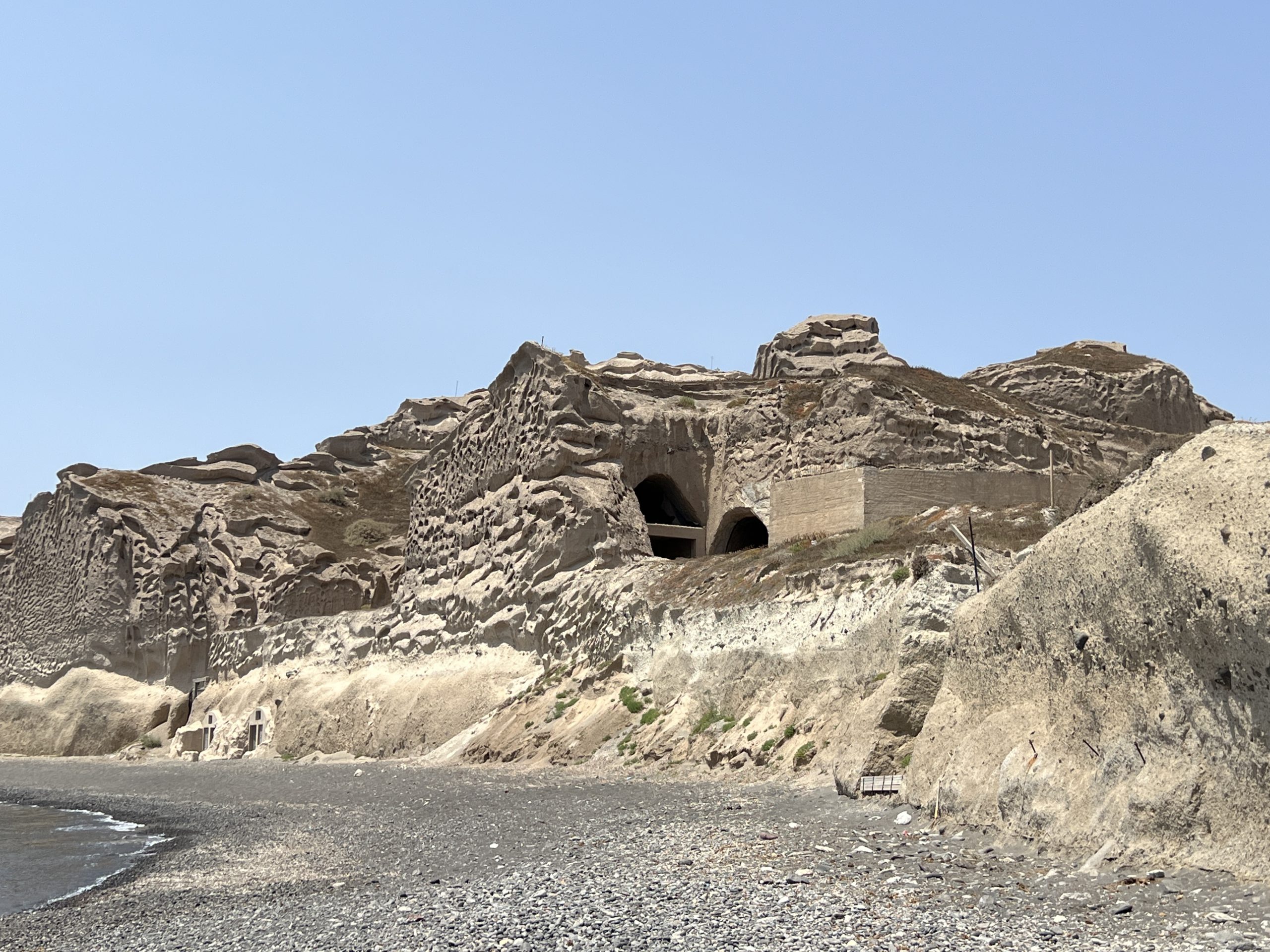 A large rock formation with two small tunnels.