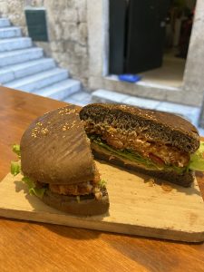 A sandwich cut in half on top of a wooden board.