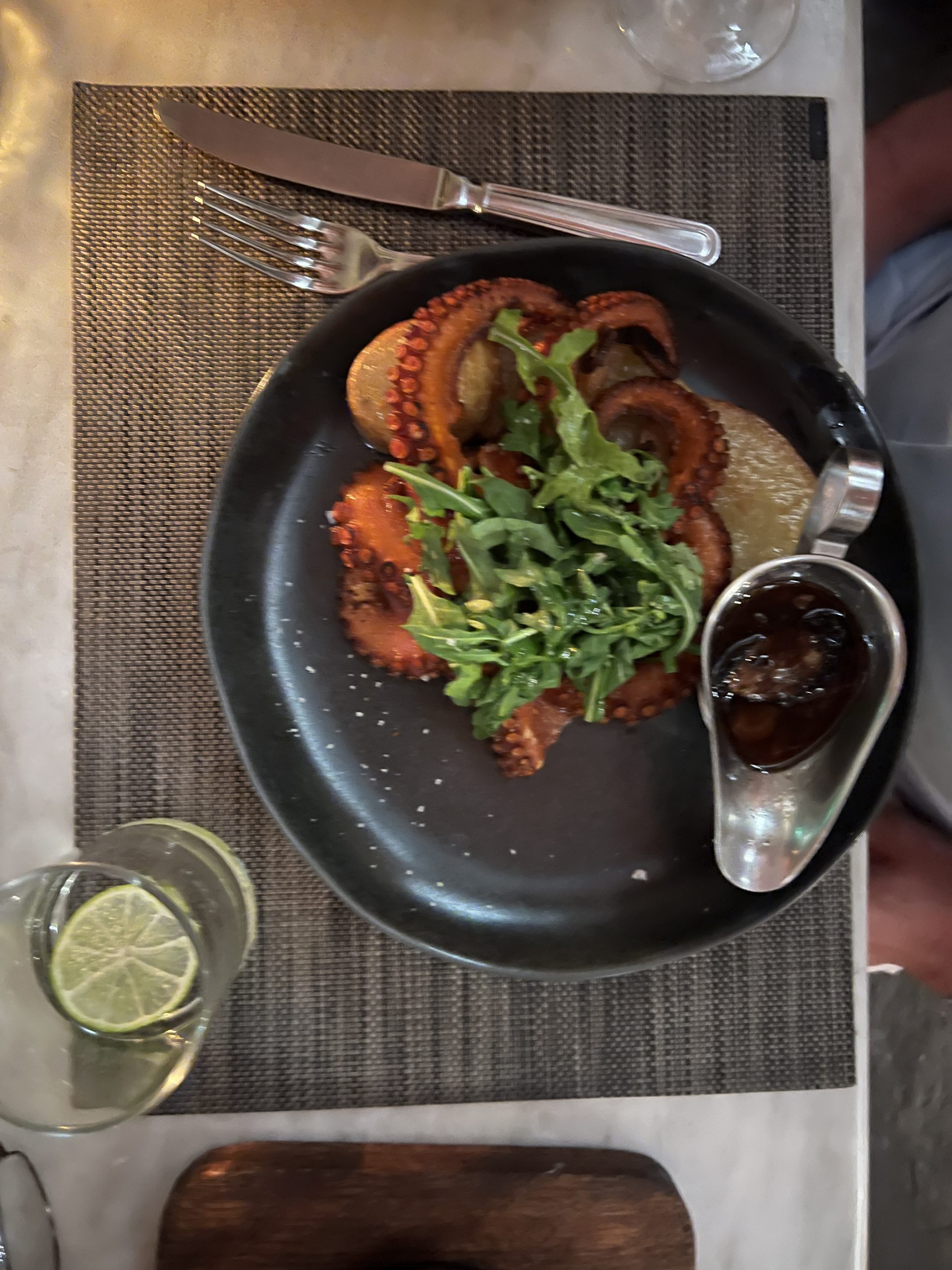 A plate of food on the table with a spoon and fork.