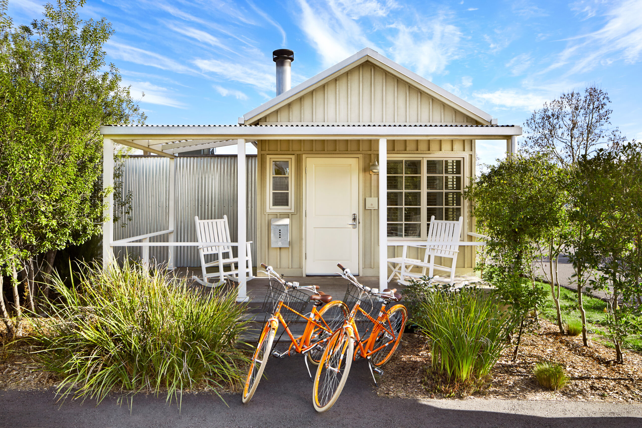 Two bicycles are parked outside of a house.