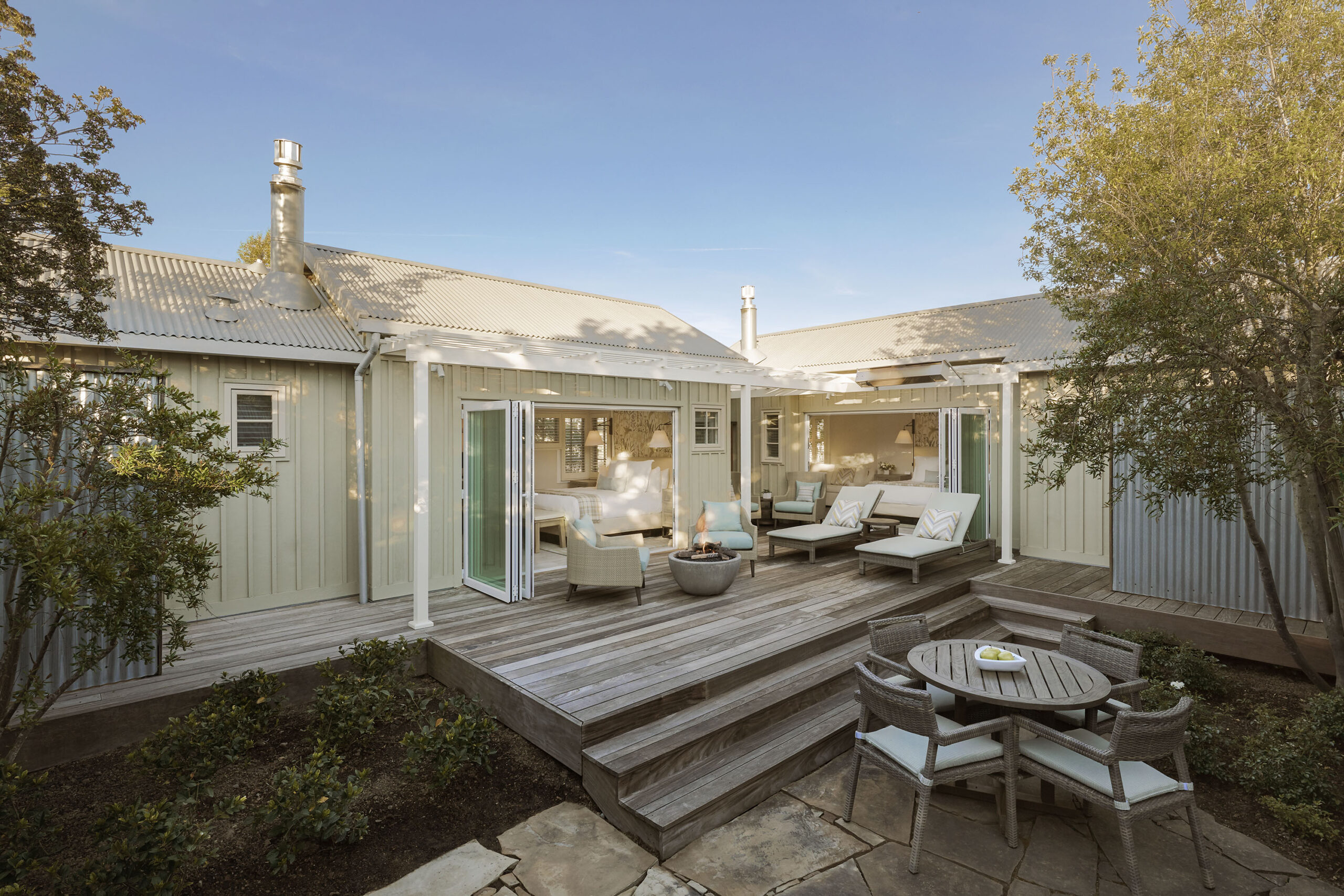 A patio with chairs and tables on the back deck.