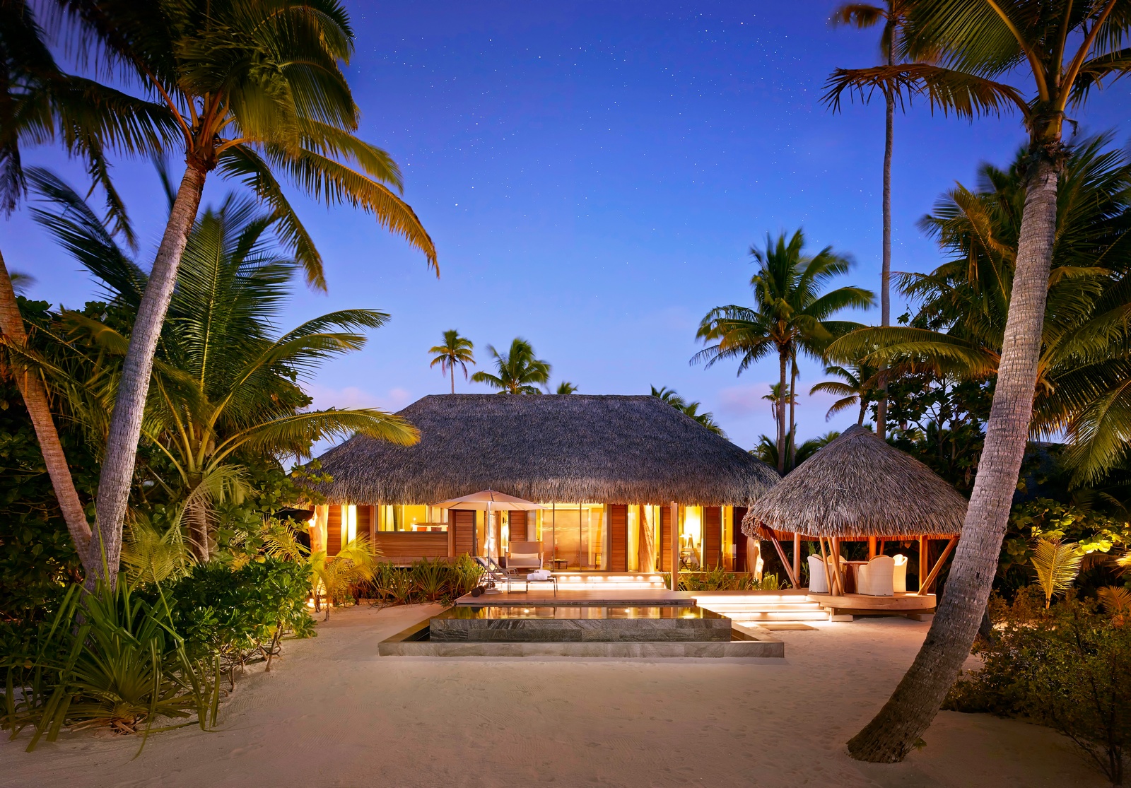 A resort with palm trees and a pool in the middle of it.