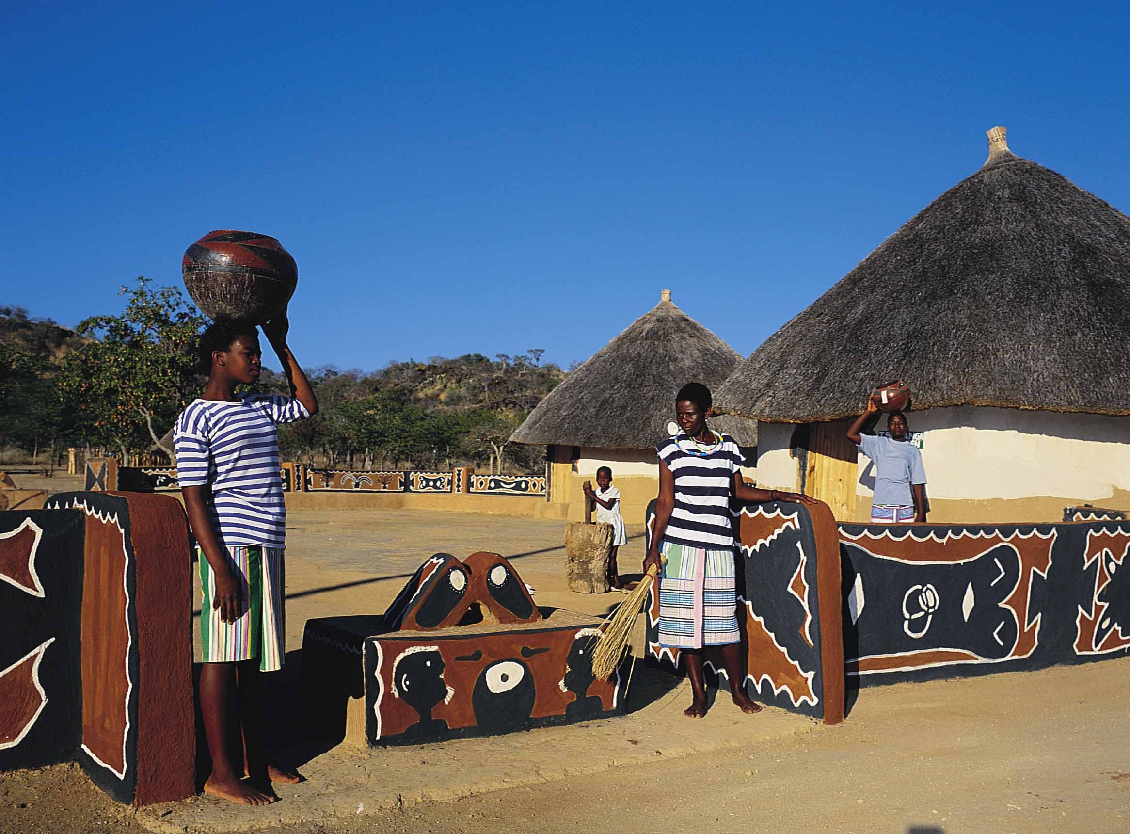 A group of people standing around in front of some houses.