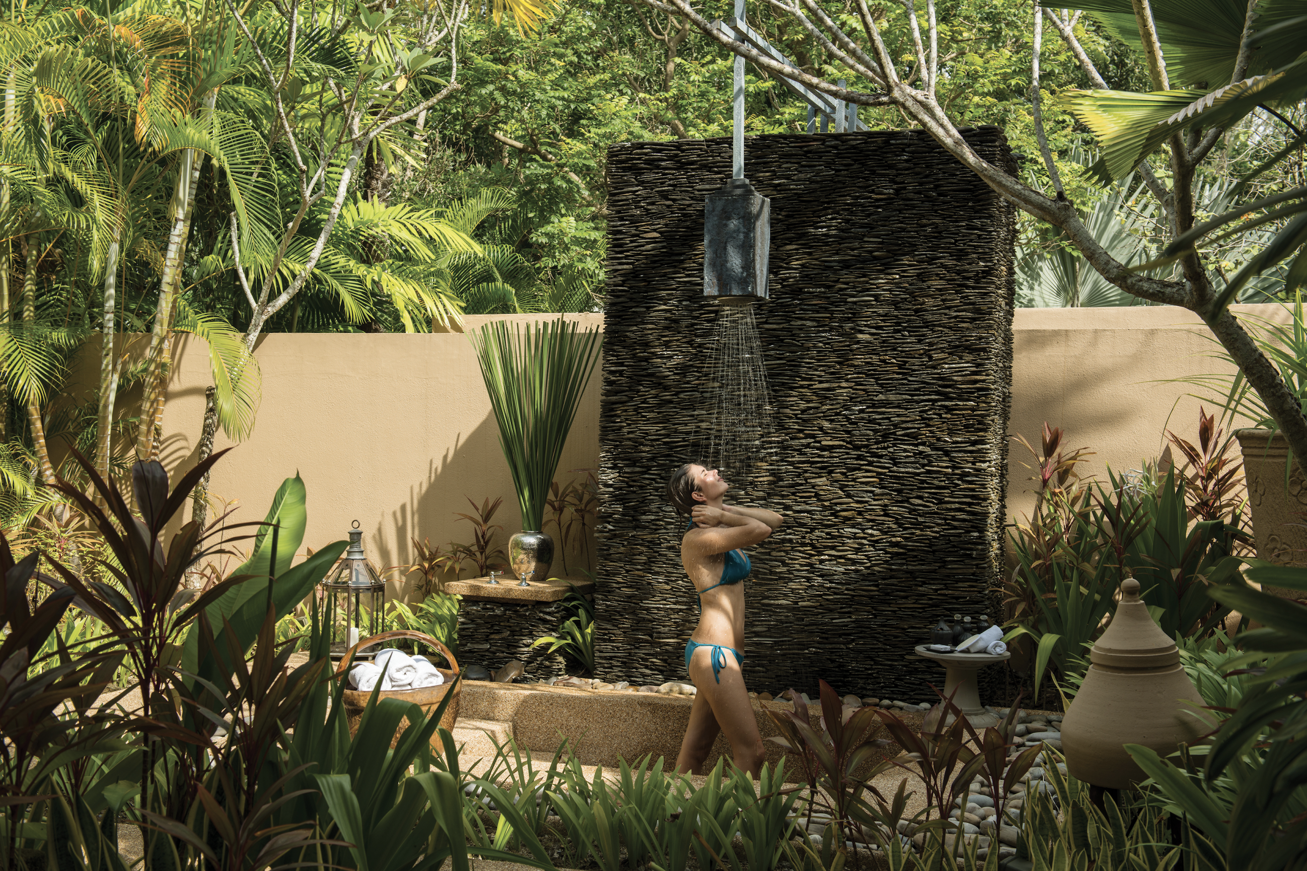 A woman in a bikini is outside by the water.