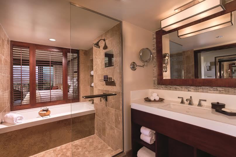 A bathroom with a large mirror and a bath tub.