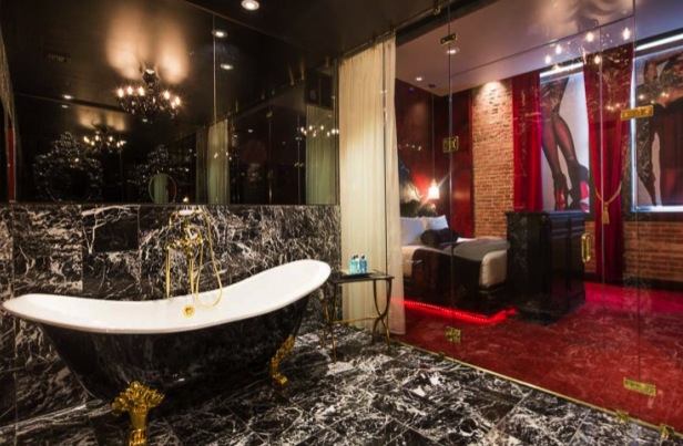 A bathroom with a tub, sink and mirror.