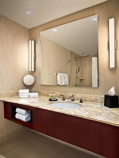 A bathroom with a large mirror and a sink.