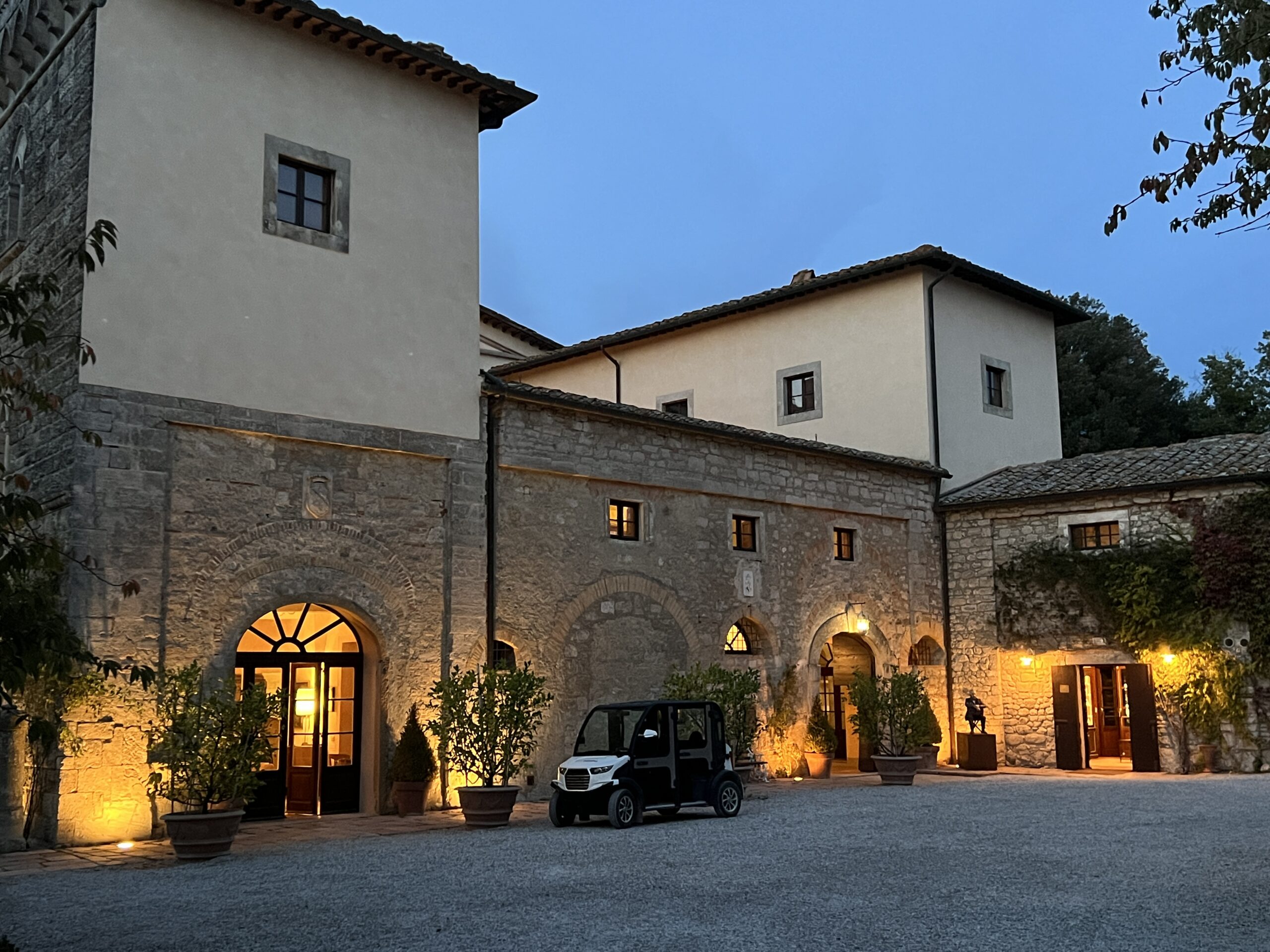 A car parked in front of a building with lights on.