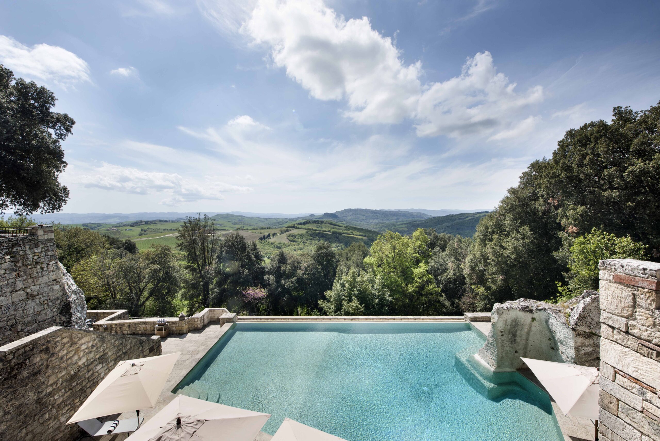 A pool with a view of the mountains and trees.