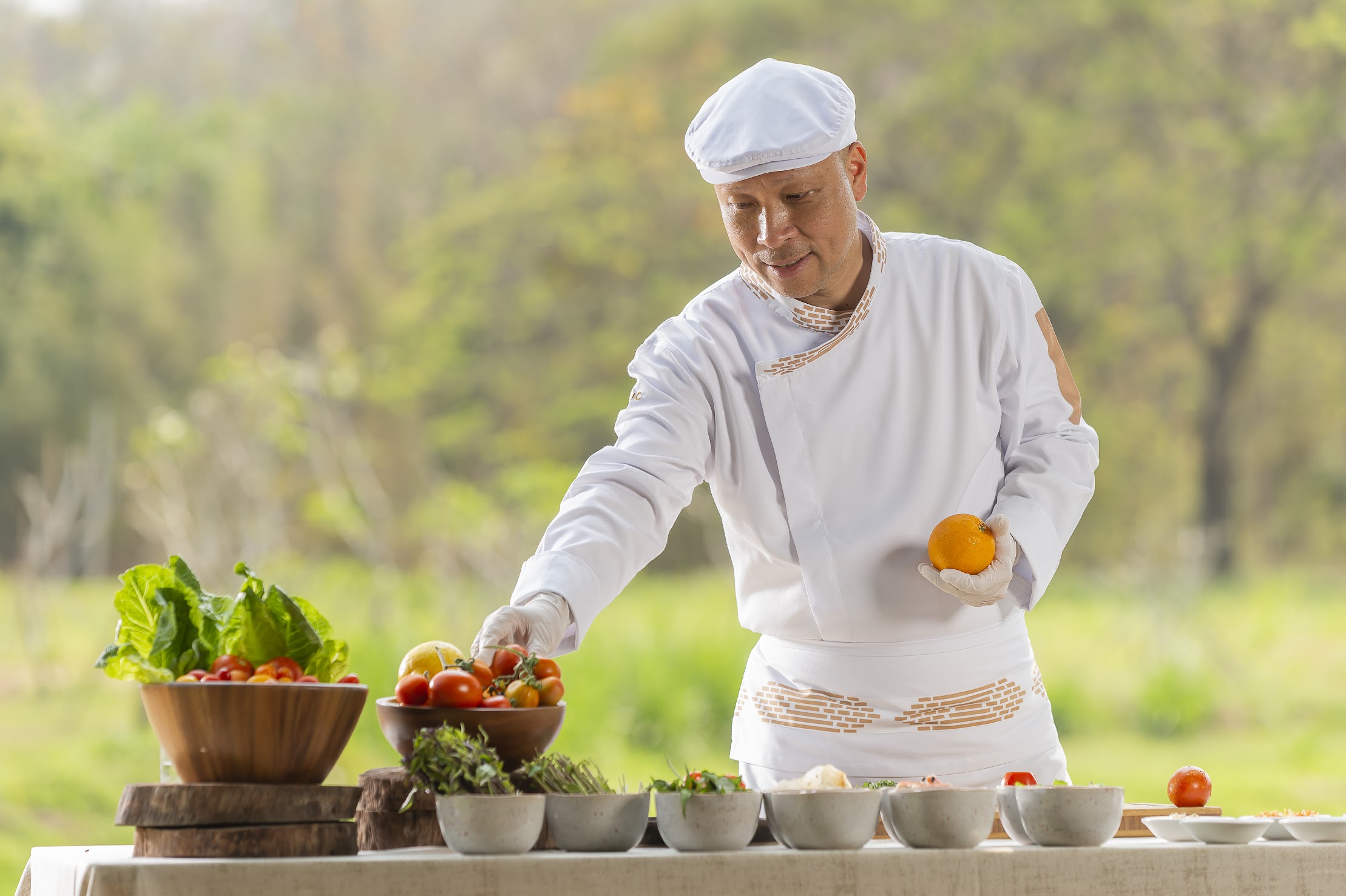 A man in white shirt and hat near bowl of fruit.