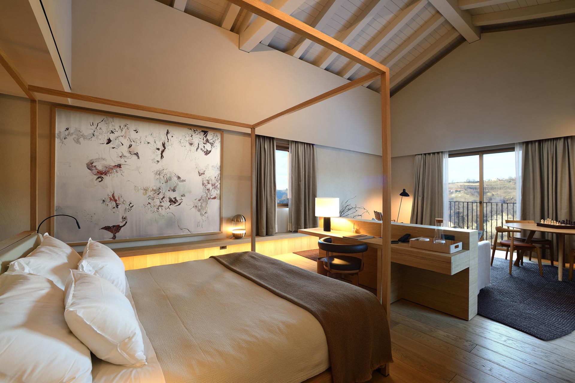 A bedroom with a large bed and a wooden floor