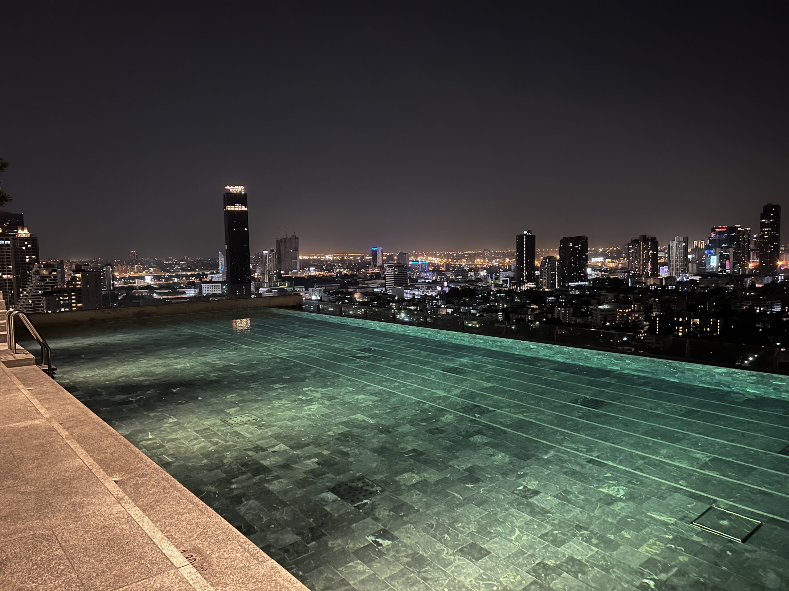 A pool with a view of the city at night.