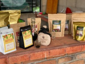 A table with various bags of coffee and a bottle.