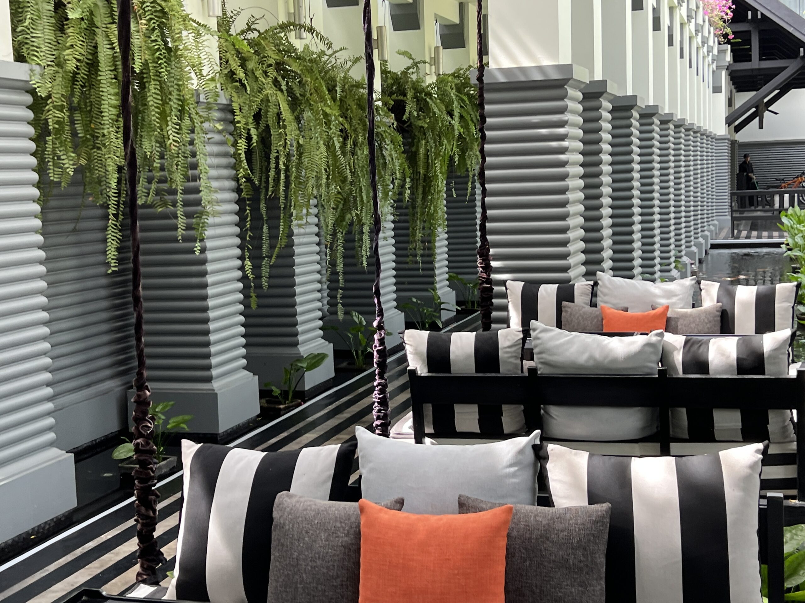 A row of black and white striped chairs with pillows.