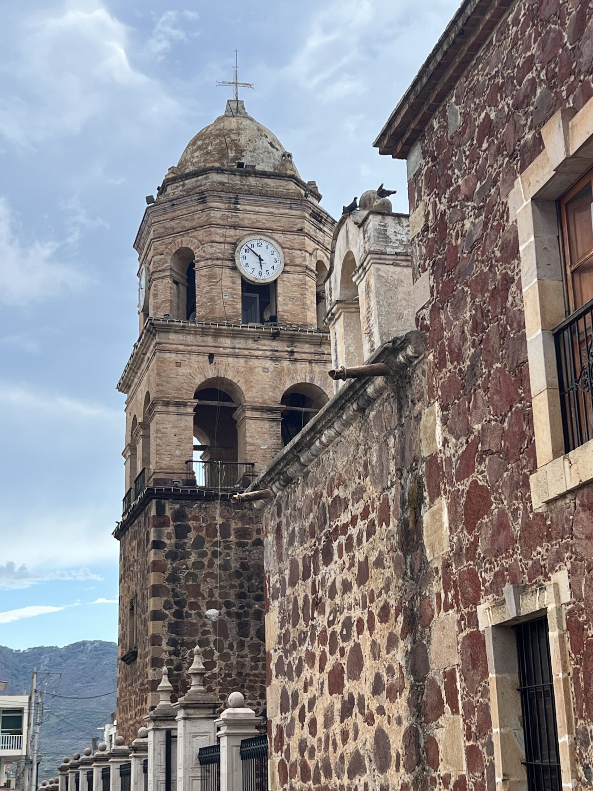 A clock tower with a bell on top of it.