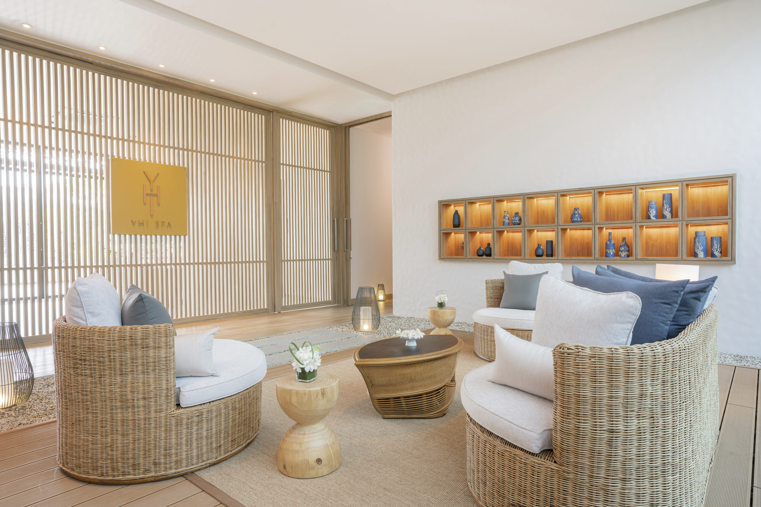 A living room with wicker furniture and a painting on the wall.