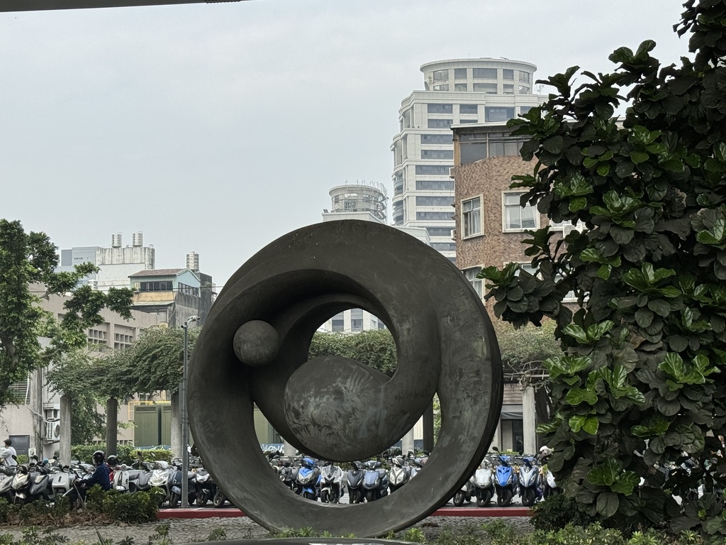 A sculpture of two circles in the middle of a park.