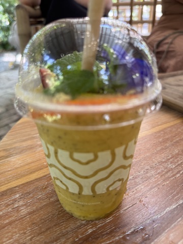 A cup of juice with a straw on top.