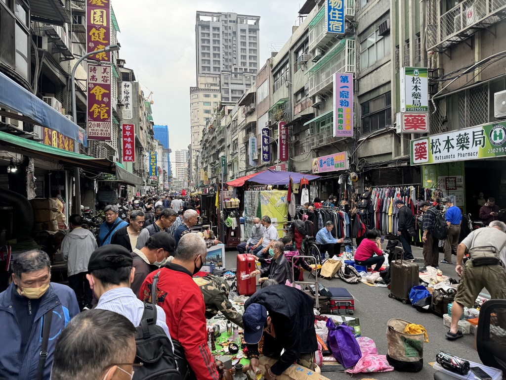 A busy street with people walking and shopping.