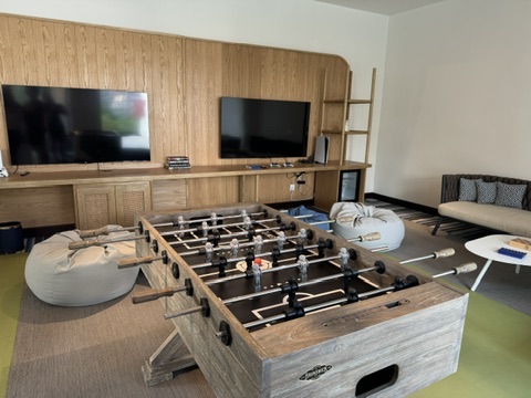 A room with a table football and television.