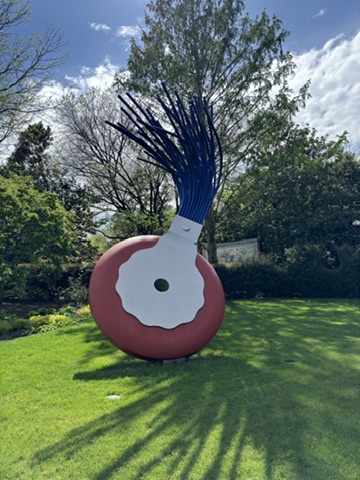 A large sculpture of a giant donut with blue hair.