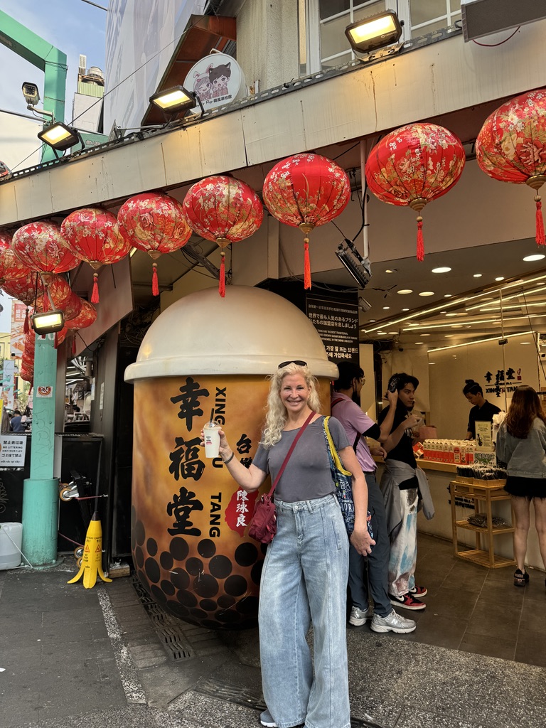 A woman standing in front of an asian restaurant.